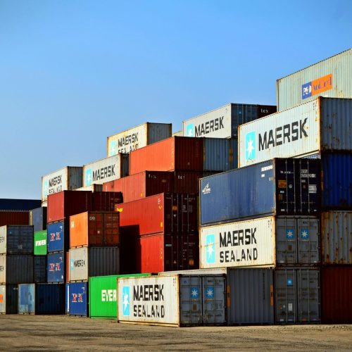 Colorful stacked shipping containers at a port exemplify global logistics.